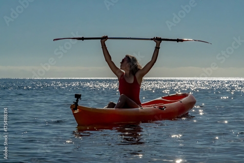 Woman, kayaking, ocean. Adventurous woman paddles across sparkling ocean water, celebrating freedom with copy space