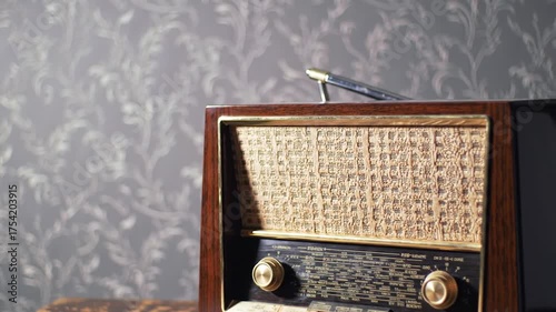 Vintage wooden radio with speaker grille and tuning dials on a patterned wall background, retro charm
