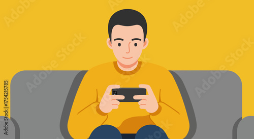 A young man in a yellow sweater sits on a grey couch, engrossed in playing a game on his smartphone, with a bright yellow background.