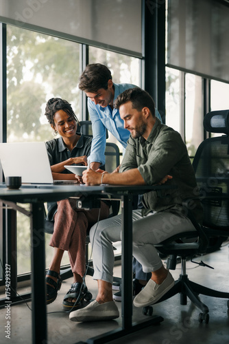 Diverse startup, business people working together on laptop computer in modern office