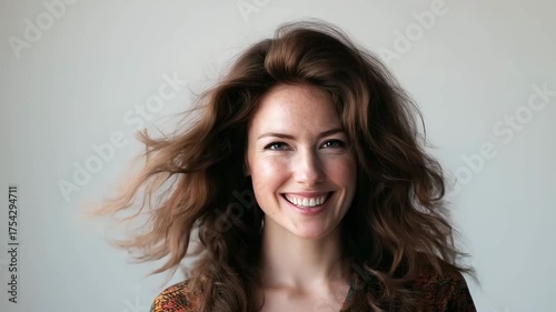 Video advertising banner  of happy smiling beautiful woman with perfect hair blowing on white background.Slow motion zoom out.AI Generative.