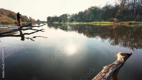 A tranquil river scene features stunning reflections in calm waters, as a kayaker navigates the serene atmosphere, surrounded by vibrant greenery and soft sunlight filtering through trees