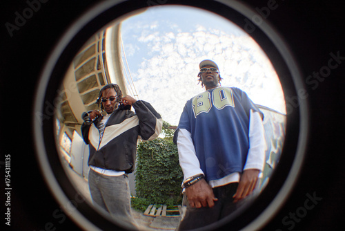 Photos Two Black young adult men standing outdoors under blue sky, wearing sunglasses a