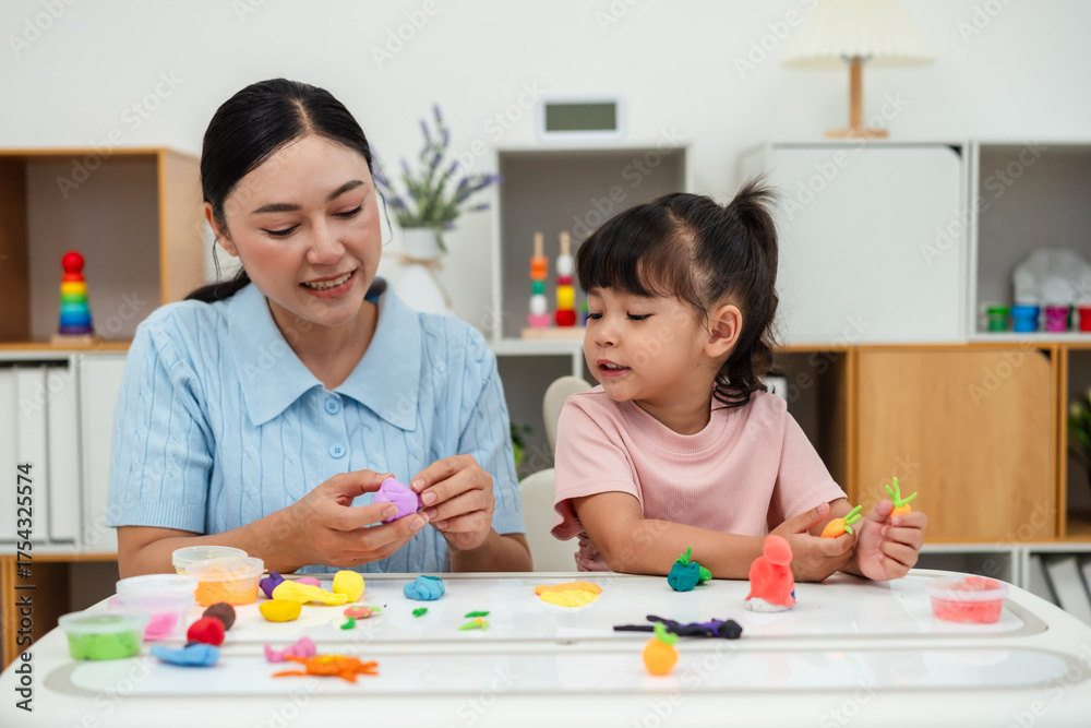 Fototapeta premium toddler girl with mother sculpting from plasticine at home