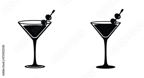 Two black and white martini glasses with olives on cocktail sticks