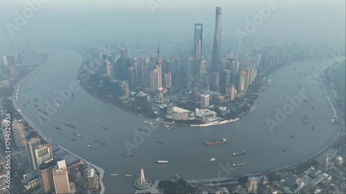 Aerial view of the Huangpu River curving through Shanghai, showcasing ships navigating the waterway and the iconic skyline, Shanghai, China.