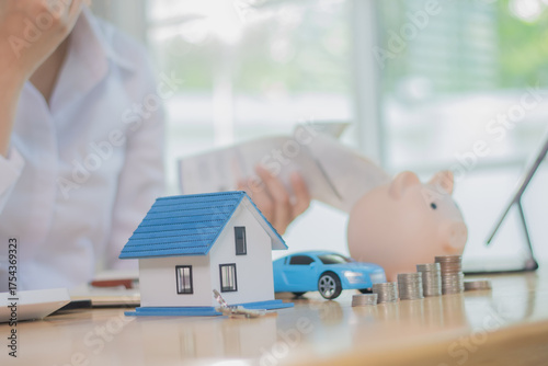 An anxious employee sits at a desk calculating taxes and mortgage payments, stressed about debt, financial problems, and uncertain future goals.