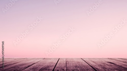 A wooden surface with clear grain texture fills the foreground against a pure pink sky,