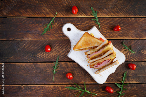 Club sandwich with ham, tomatoes, cheese and herbs. Toasts with filling