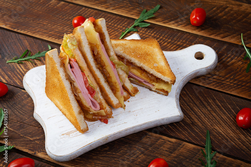 Club sandwich with ham, tomatoes, cheese and herbs. Toasts with filling