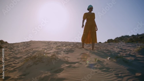 Exhausted Woman Walking Slowly Across Empty Desert Sand in Lonely Landscape