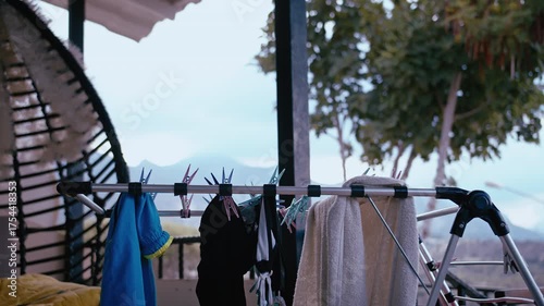 Freshly Washed Clothes Drying on Rack at Balcony with Picturesque Mountain Landscape in Background