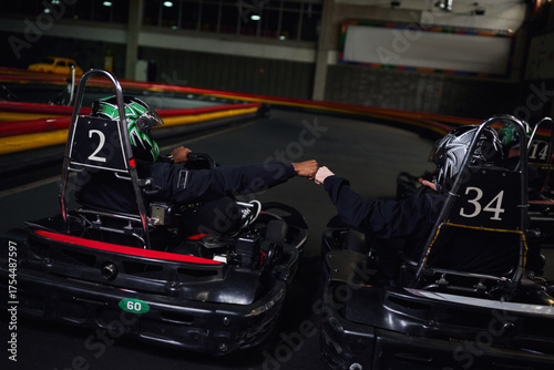 Canvas Print Friendship and excitement abound in indoor karting adventure at leisure facility
