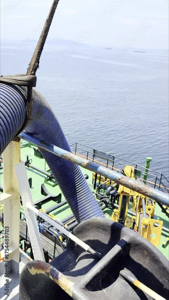 Bunkering hose connected to cargo ship during fuel transfer. Fuel ...