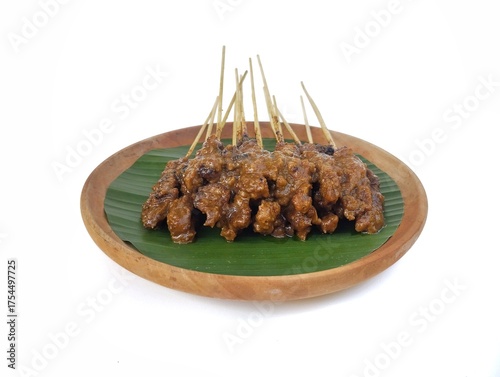 Sate ayam or chicken satay on wooden plate isolated on white background, Indonesian food