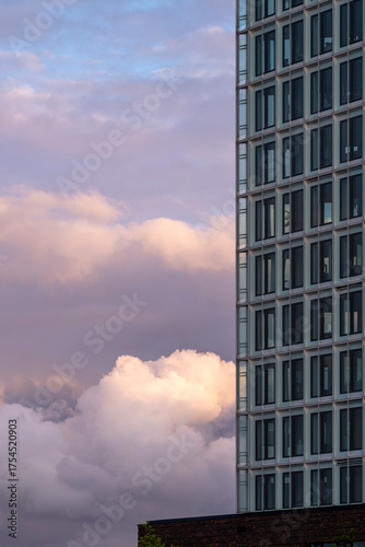 Modern glass tower with reflections of sunset sky creating warm atmosphere and copy space for corporate design and innovation themes
