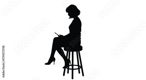 Silhouette of a woman seated on a stool, engrossed in using a digital tablet device