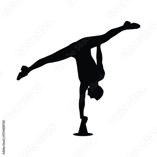 Silhouette of a flexible gymnast performing a challenging handstand balance pose on a pedestal