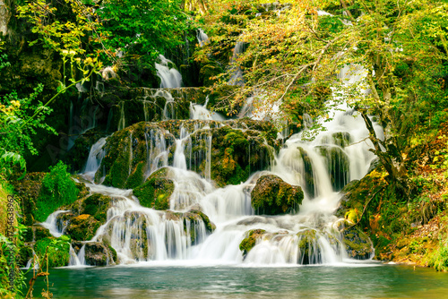 Long exposure photo of waterfall with smooth flowing water and forest surroundings