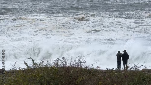 Couple at Oceanside Photographing Turbulent High Tide