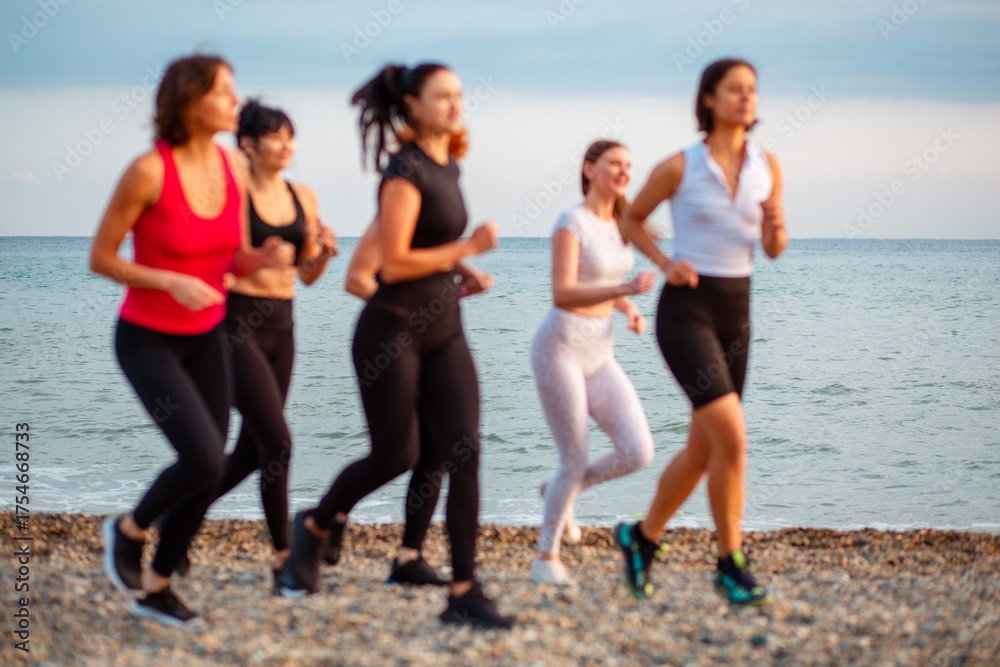 Obraz premium Group of jogging Caucasian women at clean beach. Concept of healthy lifestyle
