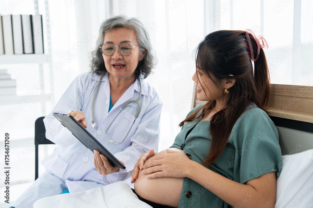 Φωτογραφία A pregnant woman sits on a hospital bed during a prenatal consultation with a smiling doctor