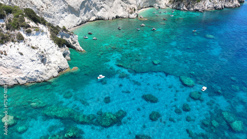 Aerial drone photo of scenic caves and beach in paradise island of Marathonisi in bay of Laganas, visited by small boats a true tourist attraction, Zakithnos island, Ionian, Greece