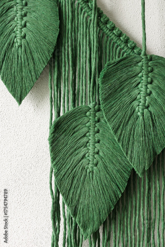 Green macrame leaves hanging on the wall. Macrame wall hanging for home decoration