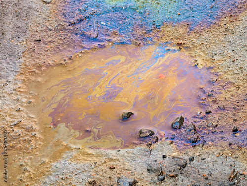 A gasoline stain in a puddle on the ground