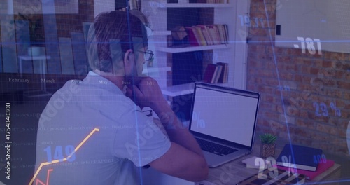 Foto Man with glasses typing code and analyzing financial charts in home office, with