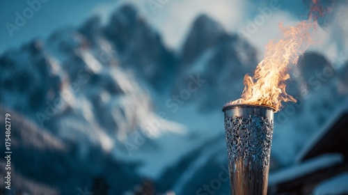 Lit Olympic torch against a backdrop of snow-covered mountains in winter. WINTER OLYMPIC GAMES CONCEPT