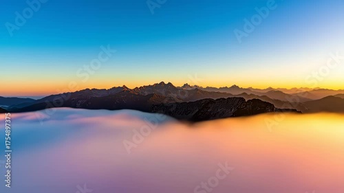 Mountain peaks emerge from a sea of colorful morning mist