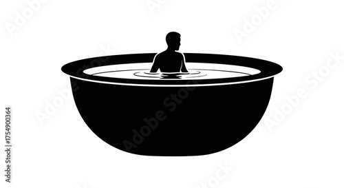 Silhouette of a person relaxing in a large bowl of water.
