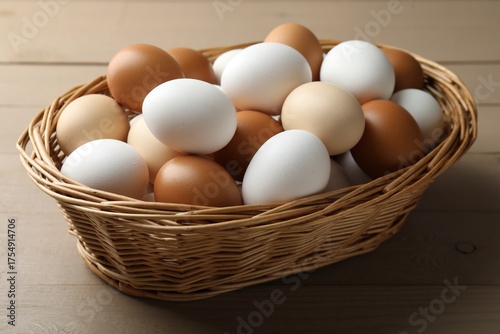 Wallpaper Mural Many raw chicken eggs in wicker basket on wooden table, closeup Torontodigital.ca