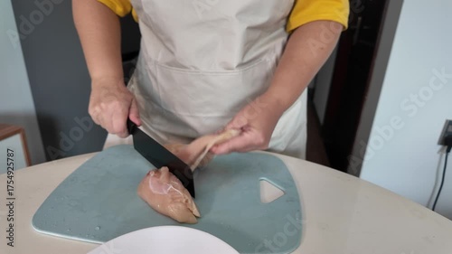 Housewife prepares dinner, cuts chicken fillet, fresh organic products. Women's hands with a knife