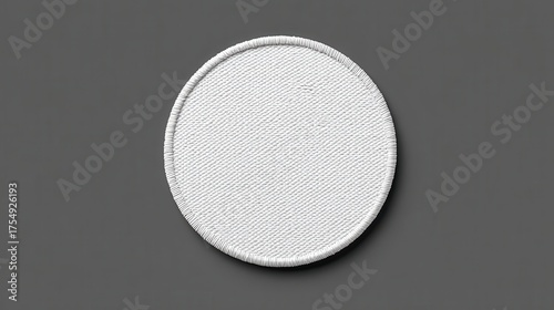 White circular fabric patch with textured surface on gray background