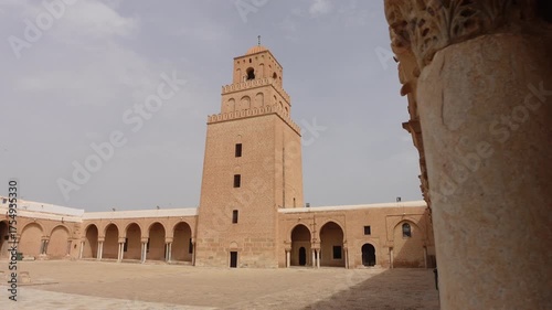 Revealing gimbal shot of tower and courtyard of the Great Mosque of Kairouan, historic landmark and place of important worship for Muslims in Tunisia Africa