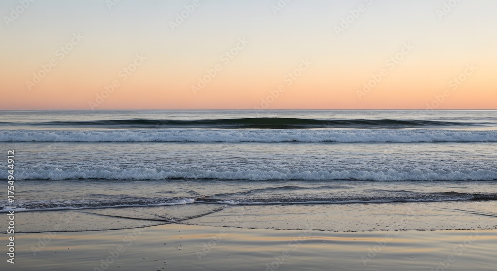 Fototapeta premium Serene ocean waves gently lapping on a sandy shore at sunset