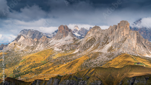 Dramatic golden light illuminates the rugged peaks of the Nuvolau and Averau mountains at Passo Giau in the Italian Dolomites, under a moody sky