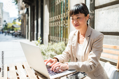 Businesswoman working on laptop outdoors