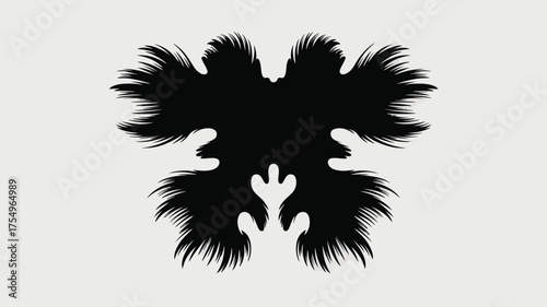 Symmetrical black ink blot with feathery edges on a white background resembling a butterfly shape