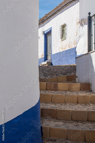 A street with stairs and white-and-blue-walled houses typical of Campo de Criptana, Ciudad Real province, Spain.