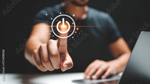 Man using laptop with pressing power button on virtual screen. Start or shut down concept.