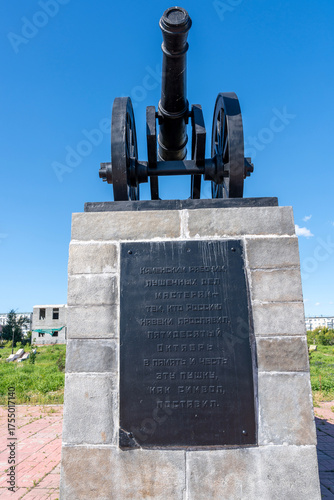 Kamenskaya cannon or gun monument or memorial on pedestal with bas-reliefs in city Kamensk-Uralsky, Sverdlovsk region, Ural. Vertical image