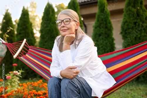 Behang Beautiful senior woman resting in hammock outdoors
