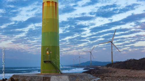White wind turbines stand on the coast