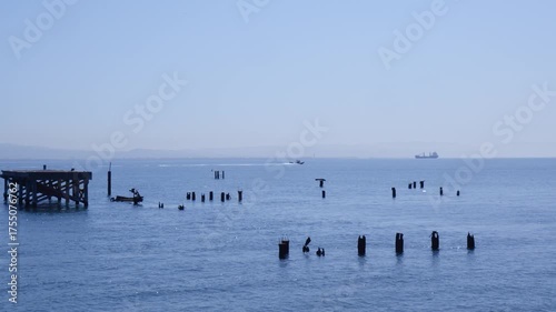 Calm Blue Ocean Waters with Distant Wooden Posts and Boat