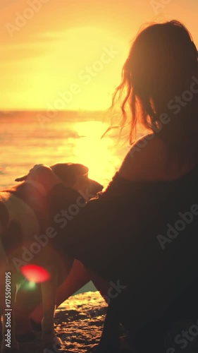 Woman sitting on beach with her dog enjoy bright colorful orange sunset over the sea. Girl female fondle her lovely pet. Feeling playful and carefree, relax, outdoor lifestyle summer holiday vacation