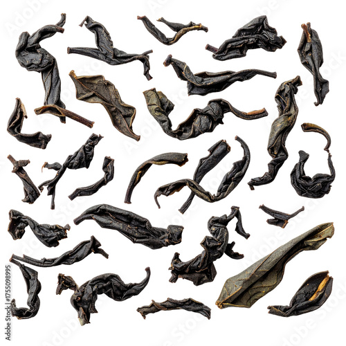 Close-up view of dried, dark-colored tea leaves scattered against a black background