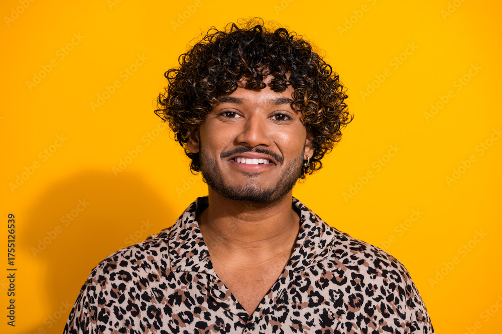 Obraz premium Happy young man on a yellow background wearing a leopard print shirt, smiling confidently and showcasing trendy fashion